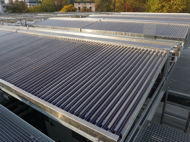 Großflächige Solarthermieanlage mit Vakuumröhrenkollektoren auf einem Dach, umgeben von herbstlicher Landschaft. Symbol für nachhaltige Energietechnologie, nominiert für den Brandenburger Innovationspreis Metall 2018.