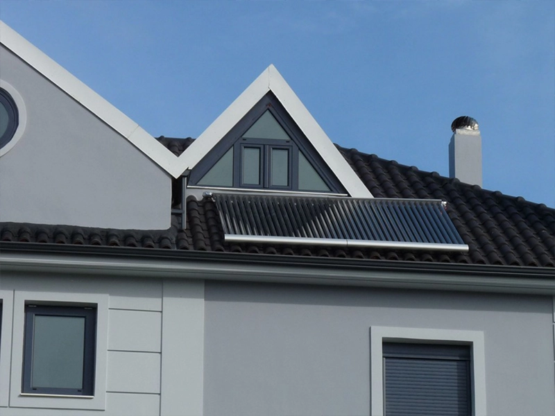 Private Solarthermieanlage von AKOTEC in Vonitsa City, montiert auf einem modernen, dunkel gedeckten Satteldach. Die Vakuumröhrenkollektoren sind optimal zur Sonne ausgerichtet und sorgen für effiziente Nutzung von Solarenergie zur umweltfreundlichen Wärmeerzeugung. Die Anlage fügt sich harmonisch in die minimalistische Architektur des Hauses ein.